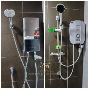 a bathroom with a water heater and a soap dispenser at J&A Seaview Suites in Perai