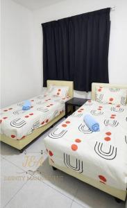 two beds sitting in a room with red and blue at J&A Seaview Suites in Perai