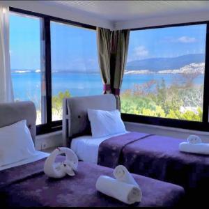 a hotel room with two beds and a large window at AKBÜK TAŞ OTEL in Akbük