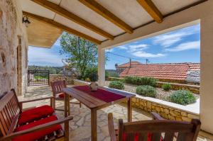 a patio with a wooden table and chairs on a balcony at Apartmani Selo Luka in Ražanj