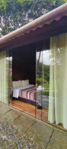 um quarto com uma cama num quarto com janelas em Pousada Silvestre em Visconde de Mauá
