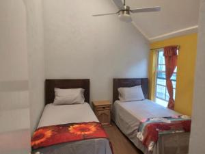 1 dormitorio con 2 camas y ventana en Casa la CEIBA, en Tancama