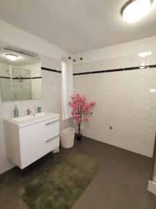 łazienka z umywalką i wazonem z kwiatami w obiekcie Maison de campagne proche Giverny La Casita de Bemi w mieście Bois-Jérôme-Saint-Ouen