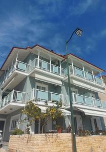 a large white building with balconies and a street light at Romanza Studios in Vasiliki