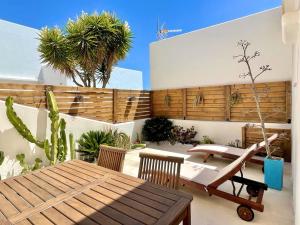 patio z drewnianym stołem, krzesłami i roślinami w obiekcie La Gata Azul Rodalquilar w mieście Rodalquilar