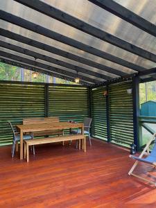 a patio with wooden tables and benches on a deck at Roztocze - Domek - Trzy Sosny in Rebizanty +11 photos