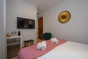 アテネにあるDema's Luxury Suitesのベッドルーム1室(ベッド1台、タオル2枚付)