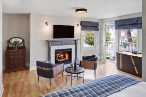 a living room with a bed and a fireplace at Gosby House Inn, A Four Sisters Inn in Pacific Grove