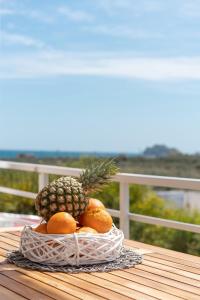 a pineapple and oranges in a basket on a table at Endless Blue in Xerokampos
