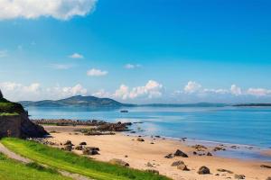 een strand met rotsen en de oceaan op een zonnige dag bij Ardmore Cottage - Failte Ireland Quality Assured in Muff