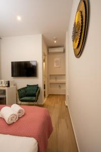 1 dormitorio con 1 cama, 1 silla y TV en Dema's Luxury Suites en Athens