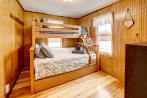 a bedroom with bunk beds in a wooden room at Waterfront House on Chippewa Lake Channel in Evart