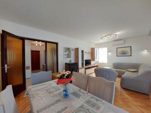 a living room with a table with a vase of flowers on it at Apartment Neda in Punat
