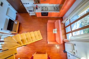 vistas panorámicas a una sala de estar con muebles de color naranja en CaseOspitali - Casa Niden il tuo nido a Cernusco vicino alla metro 2pax, en Cernusco sul Naviglio