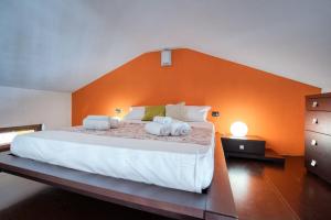 um quarto com uma cama grande e uma parede laranja em CaseOspitali - Casa Niden il tuo nido a Cernusco vicino alla metro 2pax em Cernusco sul Naviglio