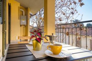 einen Tisch mit einer Tasse Kaffee auf dem Balkon in der Unterkunft CaseOspitali - Casa Niden il tuo nido a Cernusco vicino alla metro 2pax in Cernusco sul Naviglio