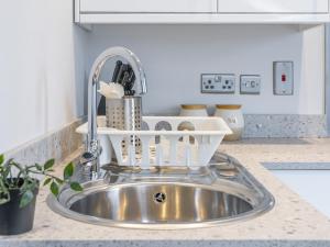 a kitchen sink with a dish drying rack next to it at Pass the Keys Top Floor Apt Queens Uni Walk Everywhere in Belfast