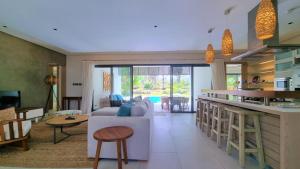 uma cozinha e sala de estar com um sofá e uma mesa em Superior 4-Bedroom Villa at Anahita Golf & Spa Resort's em Beau Champ