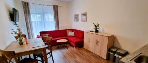 a living room with a red couch and a table at Apartmánový dom Lúčky 188 in Demanovska Dolina