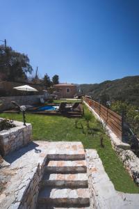 un cortile con un sentiero in pietra e una piscina di Ampelos Cretan Villa - Private Pool & Heated Ozone Jacuzzi a Yerolákkos