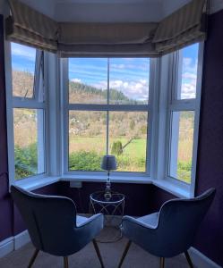 2 Stühle vor einem Fenster mit Aussicht in der Unterkunft Llety Betws in Betws-y-coed