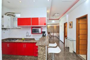 cocina con armarios rojos y encimera en Nice penthouse with pool, close to the beach en Río de Janeiro