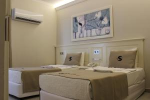 two beds in a hotel room with a air conditioner at Savk Hotel in Alanya