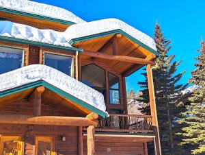 a log cabin with a snow covered roof at Moose Tree Lodge in Whitefish