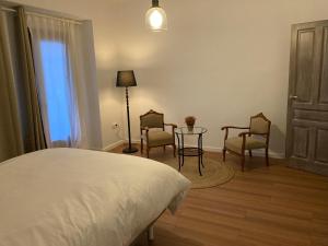 ein Schlafzimmer mit einem Bett, Stühlen und einem Tisch in der Unterkunft Casa Ferma in Teruel