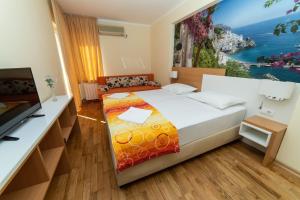 Un dormitorio pequeño con una cama y un televisor. en Hotel Obala, en Budva