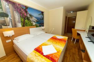 a hotel room with a bed with a laptop on it at Hotel Obala in Budva