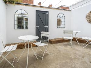 a group of chairs and tables in front of a white wall at Pass the Keys Rathcool Gorgeous Terrace with Outdoor Living Cafes and Bars in Belfast