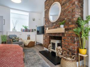 a living room with a brick fireplace with a mirror at Pass the Keys Rathcool Gorgeous Terrace with Outdoor Living Cafes and Bars in Belfast