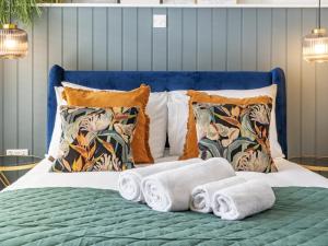 Una cama con toallas y almohadas. en Pass the Keys Rathcool Gorgeous Terrace with Outdoor Living Cafes and Bars en Belfast