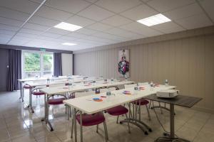 ドゥエ・ラ・フォンテーヌにあるThe Originals City, Hôtel La Saulaie, Saumur Ouestのテーブルと椅子が置かれた広い部屋