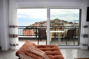 a living room with a couch and a balcony with a view at Bella Vista in Kavála