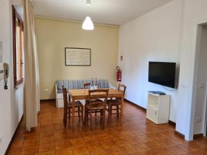 comedor con mesa, sillas y TV en Caletta Apartments, en Castiglioncello
