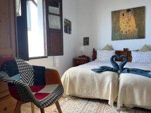 a bedroom with a bed and a chair with towels on it at Casa Lucia in Genovés