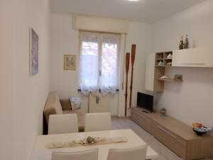 a living room with a table and chairs and a television at Casa Mariuccia in Santa Margherita Ligure