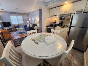 特拉弗斯城的住宿－North Shore Inn TC 300，厨房以及带白色桌椅的用餐室。