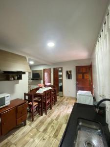 a kitchen and living room with a table and a dining room at Colina do Cristal in Santo Antônio do Pinhal