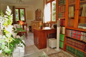 eine Bibliothek mit einem Schreibtisch und Bücherregalen in der Unterkunft LOU PANTAI in Villeneuve-Loubet