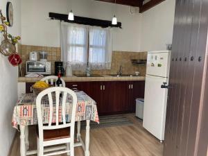 a kitchen with a table and a white refrigerator at Casa Lucia in Genovés