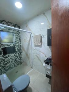 a bathroom with a shower and a toilet and a television at Colina do Cristal in Santo Antônio do Pinhal