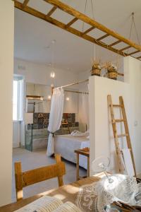 a room with a bed and a kitchen with a ladder at Masseria Rauccio in Torre dell'Orso