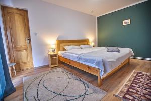 a bedroom with a large bed and a green wall at Insula Christiana in Cristian