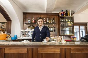 塞拉倫加達爾巴的住宿－Locanda Italia，站在酒吧喝杯咖啡的人