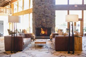 a living room with couches and a stone fireplace at Snow King Resort in Jackson