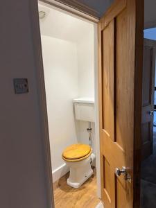 a bathroom with a toilet with a wooden seat at Station House-Hinton Admiral in Christchurch