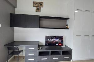 a room with a desk with a tv on a wall at Inspired Homes @ PJ Grand Sofo#10, Free Parking, 2Pax in Petaling Jaya
